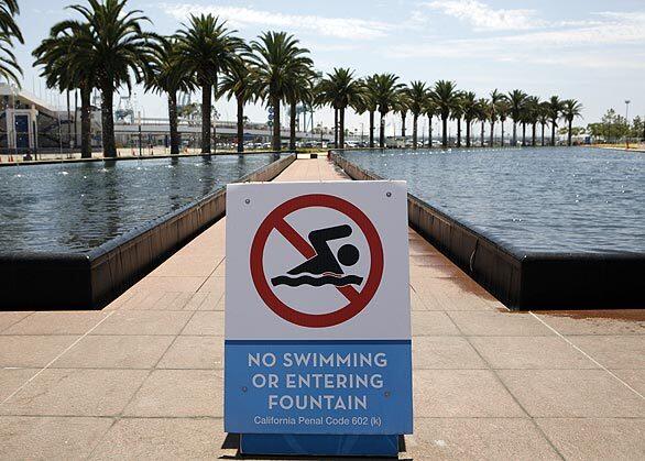 A sign warns against inappropriate fountain behavior. Some teenagers have jumped into the fountain, authorities say.