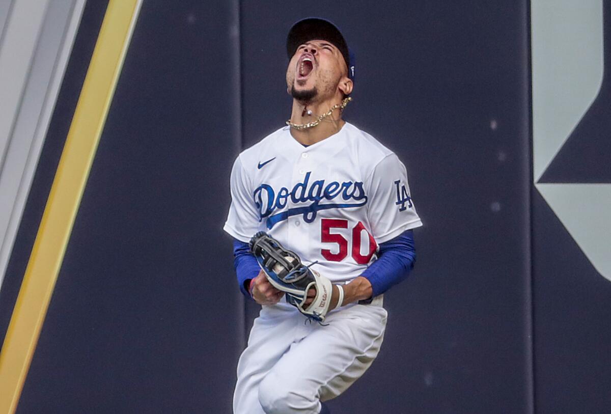 Dodgers right fielder Mookie Betts celebrates after making a leaping catch at the wall.