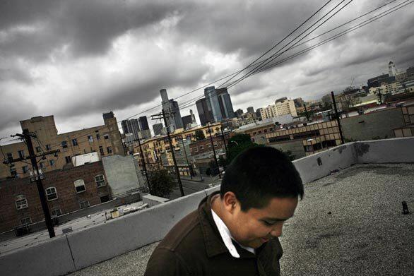 Kevin Cedano, 13, who has grown up on L.A.'s skid row, walks on the roof of the Ohio Hotel, where he lives with his parents and three sisters. The area is a desert for most children, with few accessible parks or diversions other than the street. Kevin has struggled with staying in school, not for lack of good grades but because many public schools are reluctant to admit students from what they see as a troubled neighborhood.