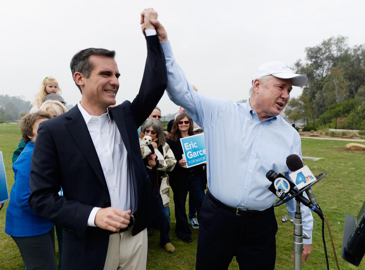 Los Angeles City Councilman Tom LaBonge, right, raises the arm of fellow Councilman Eric Garcetti after endorsing him for mayor at a Silver Lake park.