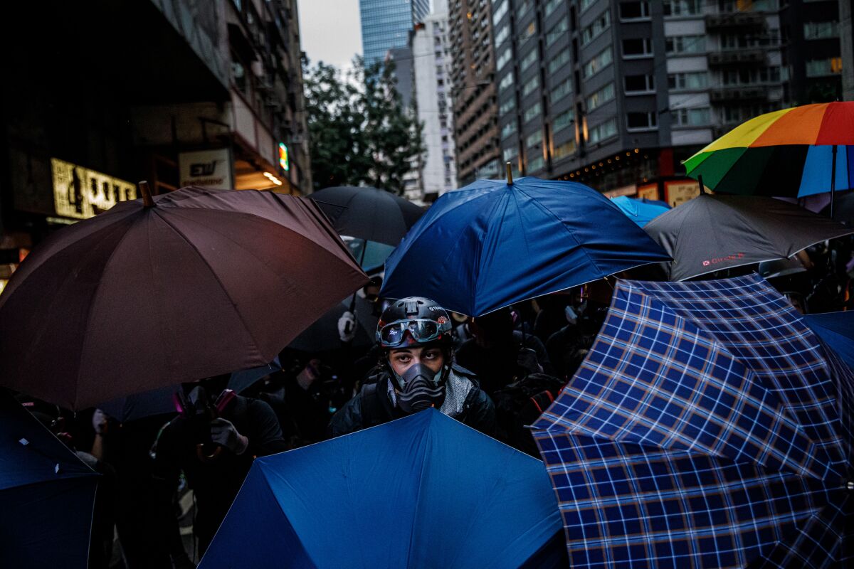 Anti-government demonstrators retreat with umbrellas open as police make their advance after a peaceful rally turns violent on Oct. 6, 2019.