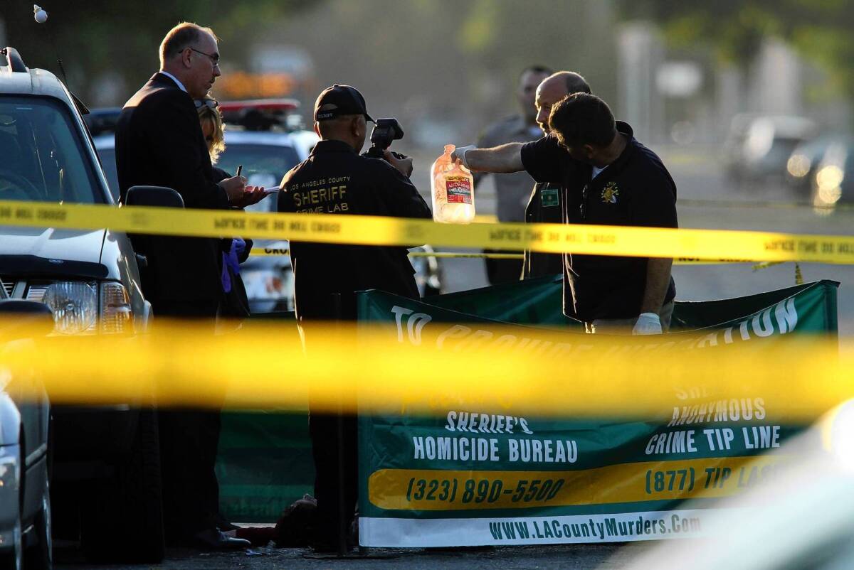 Sheriff's investigators examine the scene of a fatal shooting in Lynwood in September. There were 166 killings in the Los Angeles County Sheriff's Department's patrol areas in 2012, the fewest since 1970.