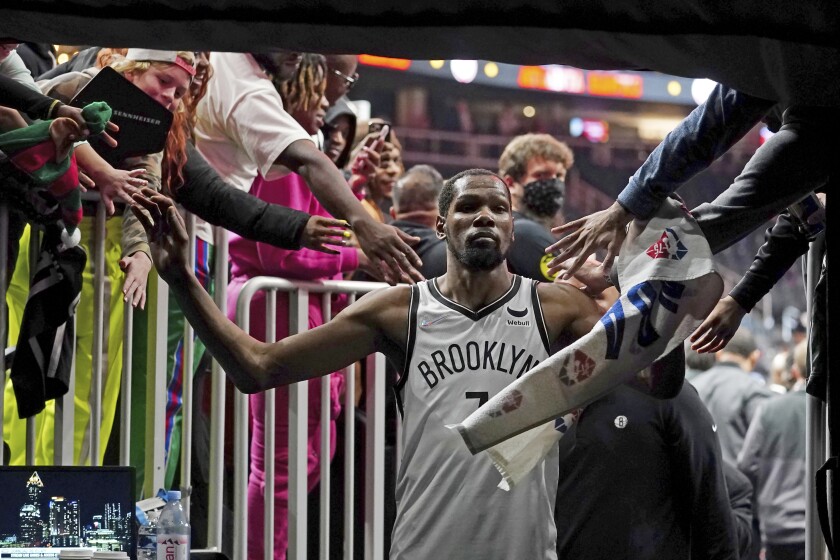 Brooklyn Nets forward Kevin Durant (7) makes his way past fans as he walks to the locker room after the Nets defeated the Atlanta Hawks in an NBA basketball game Friday, Dec. 10, 2021, in Atlanta. (AP Photo/John Bazemore)