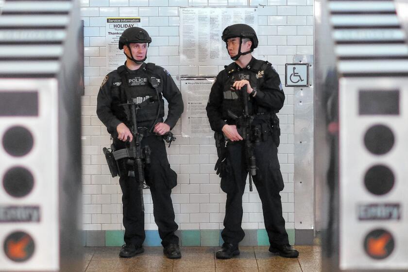New York police officers guard a subway entrance at Times Square on Wednesday, five days after the Paris attacks.