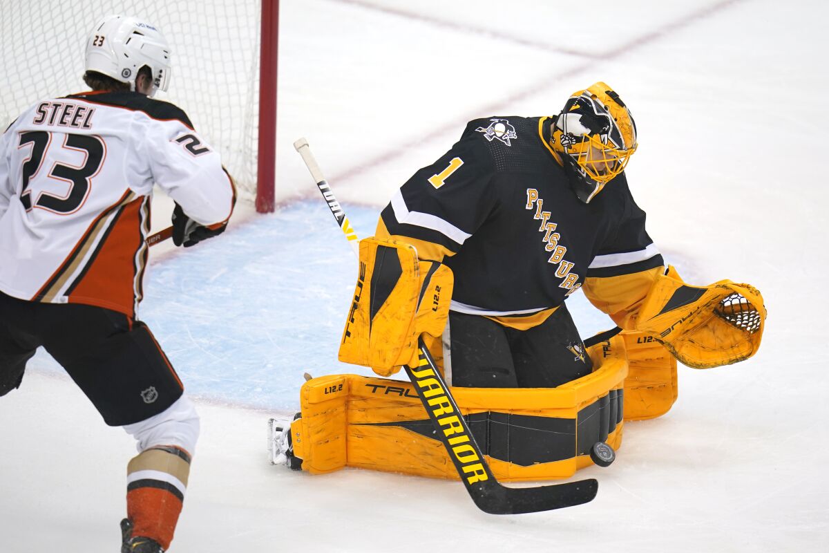 Penguins goalie Casey DeSmith blocks a shot as the Ducks' Sam Steel looks for a rebound Dec. 11, 2021.