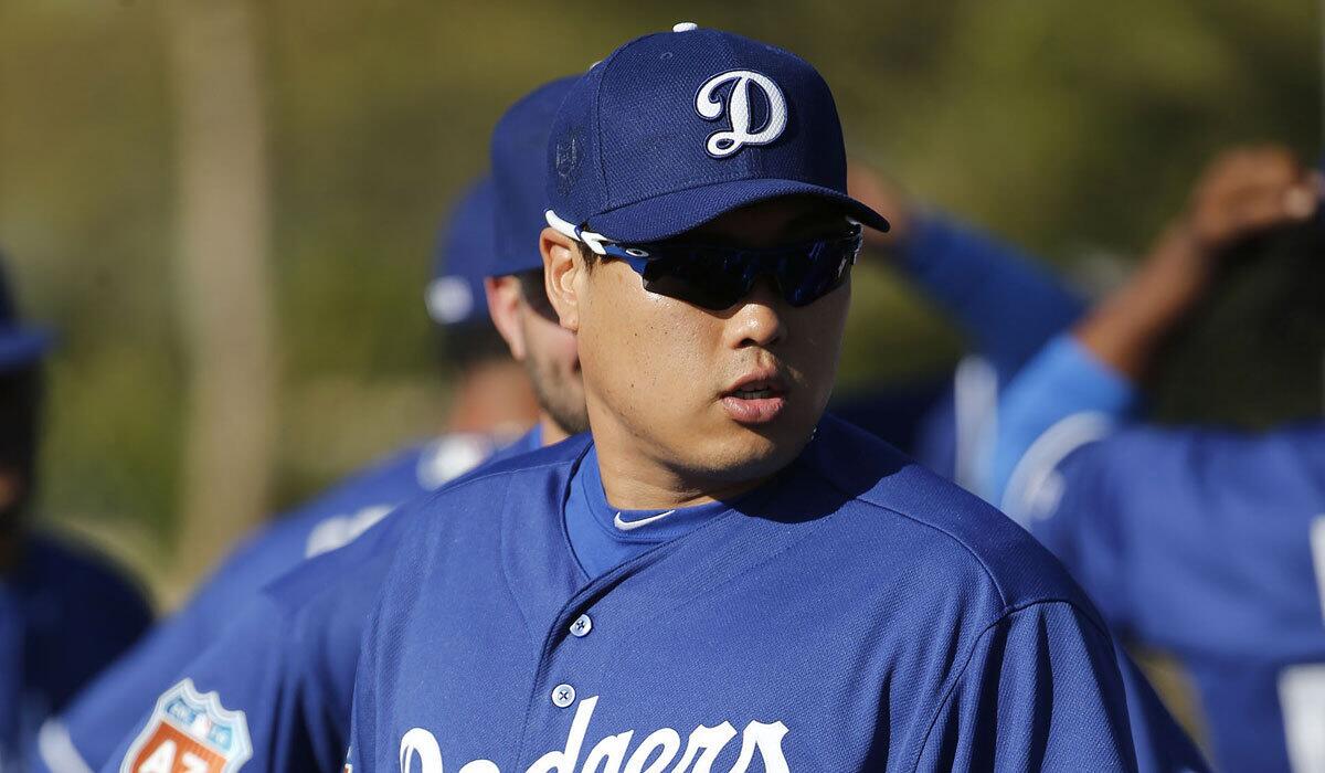 Hyun-Jin Ryu waits with teammates prior to a spring training baseball workout in Glendale, Ariz., on Feb. 22.