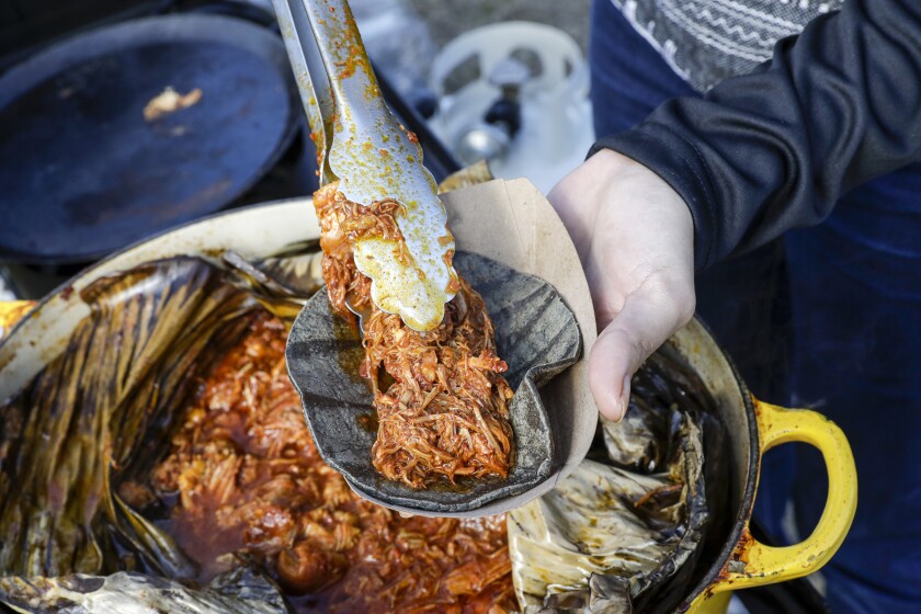 Tania Macin prepares a cochinita pibil taco at her taco stand in Echo Park.