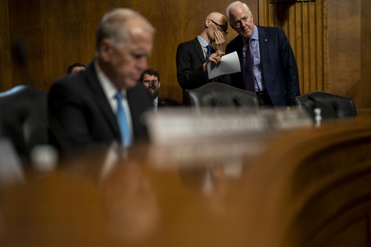Sen. John Cornyn (R-TX) confers with an aide after arriving at a Senate Judiciary Subcommittee on Tuesday.