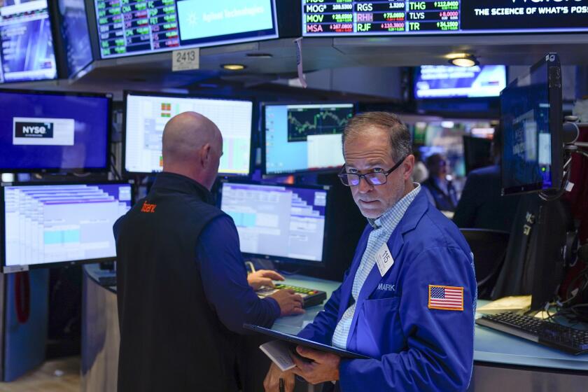 FILE = Traders work on the floor at the New York Stock Exchange in New York, Wednesday, July 26, 2023. Fees for mutual funds and exchange-traded funds fell to a record low last year, according to Morningstar. Fund investors paid about $37 in fees for every $10,000 invested, down from $40 in 2021. Altogether, that saved them a collective $9.8 billion. (AP Photo/Seth Wenig, File)