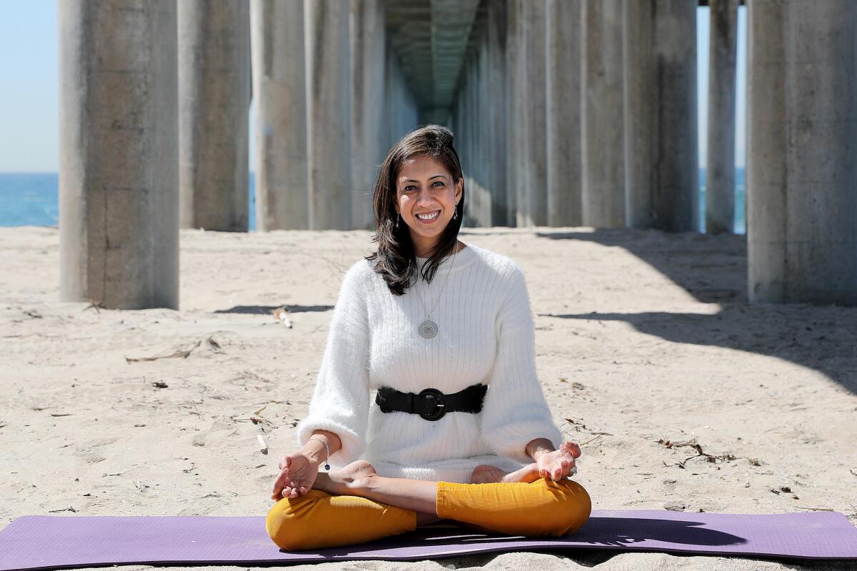 Poddar strikes a lotus pose underneath the main pier in Huntington Beach, a city that appears as a setting in "Border Less."