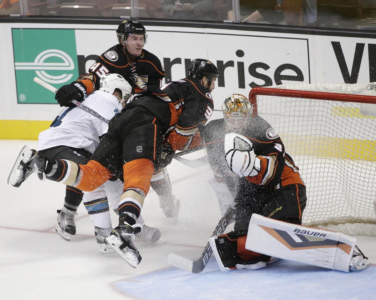 San Jose's Bryan Lerg collides with the Ducks' Sami Vatanen (45) and Clayton Stoner (3) as they skate past goalie Frederik Andersen during a preseason game on Oct. 3.