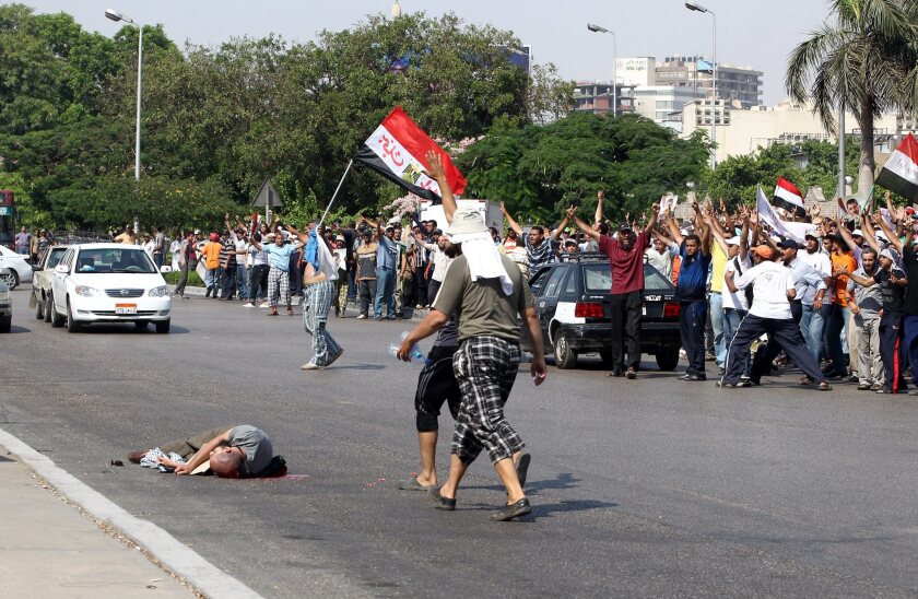 The body of a supporter of ousted Egyptian President Mohamed Morsi lies on the ground after he was shot dead during clashes in Cairo.