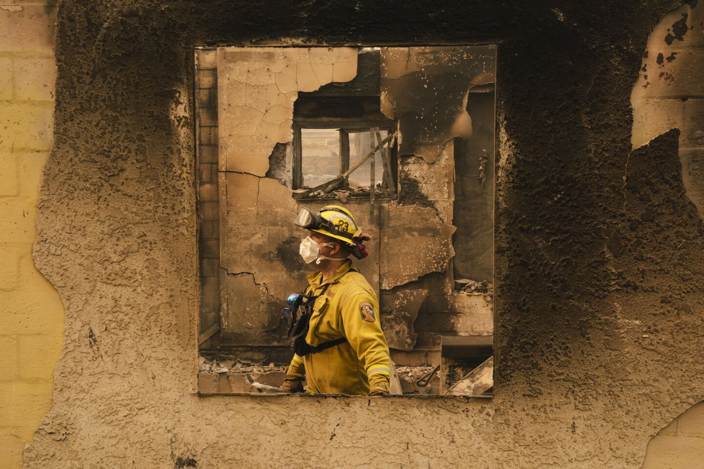 Firefighters walk through the rubble of a home in Paradise, Calif.