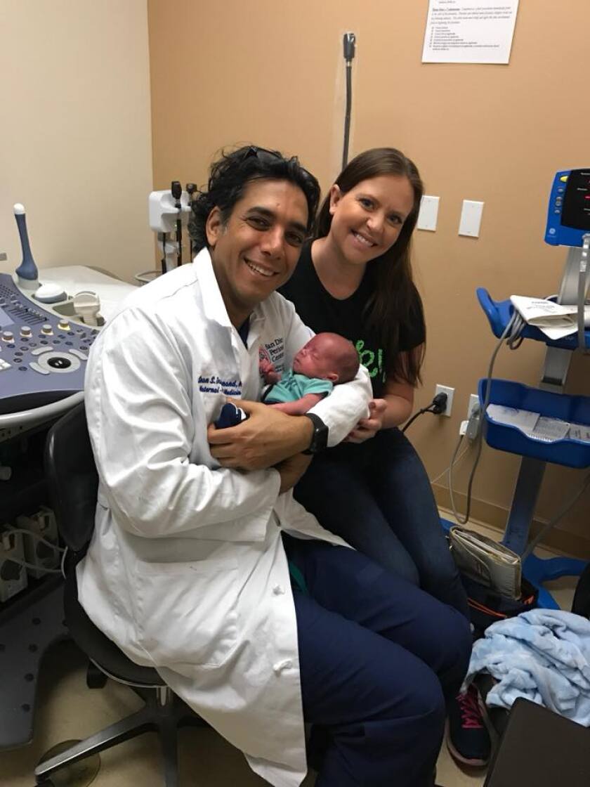 Dr. Sean S. Daneshmand, director of Scripps Clinic’s maternal-fetal medicine program, is seen here with a newborn baby and mother.