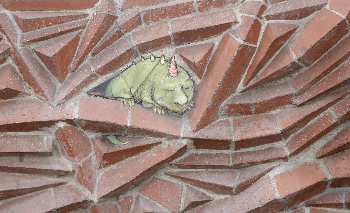 One of David Zinn's whimsical street art characters drawn on a brick wall on the Promenade on Forest in Laguna Beach.