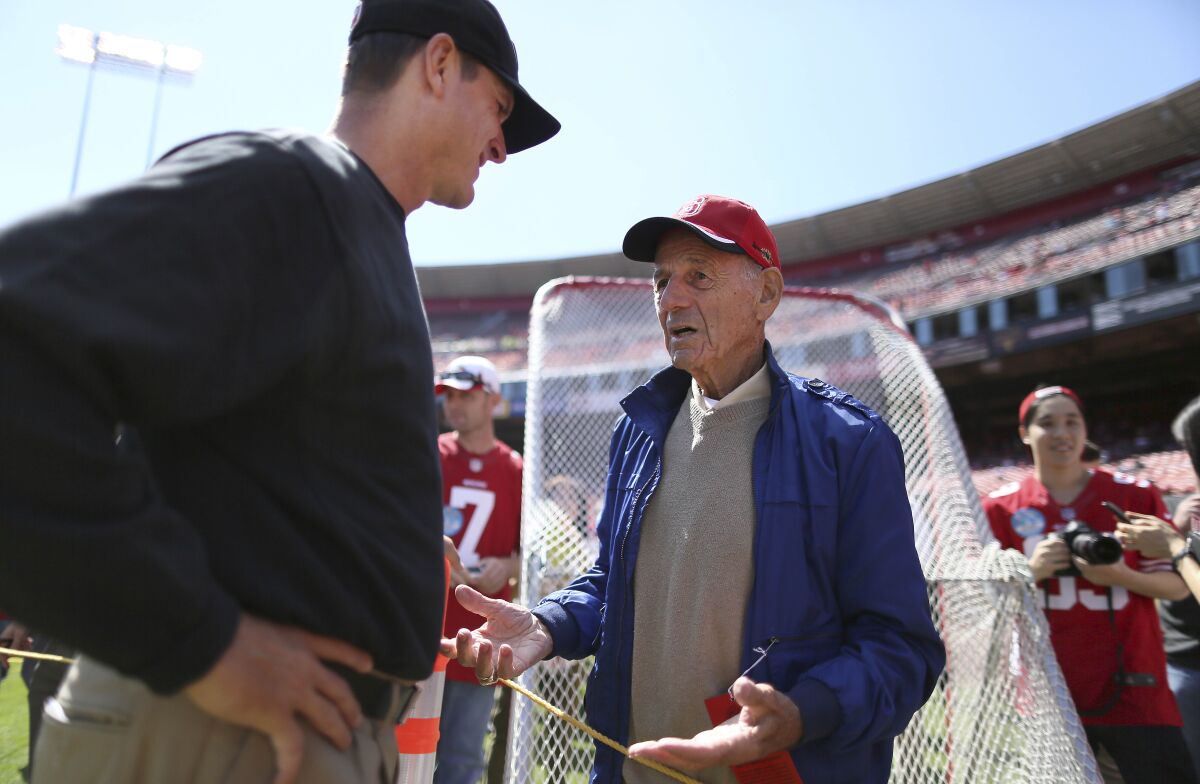 San Francisco 49ers head coach Jim Harbaugh, left, talks to former coach Dick Coury in 2013.