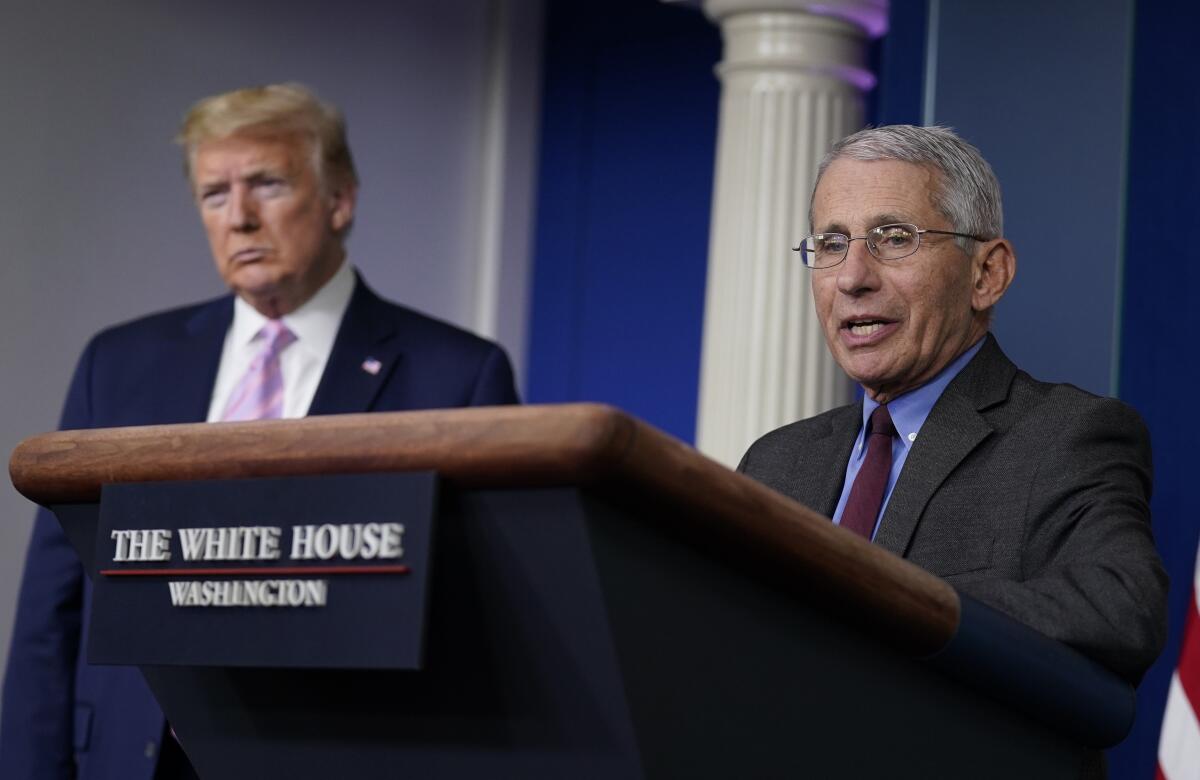 President Trump listens as Dr. Anthony Fauci, the director of the National Institute of Allergy and Infectious Diseases, speaks during a coronavirus briefing at the White House earlier this month. In recent days, their relationship has been fraught.