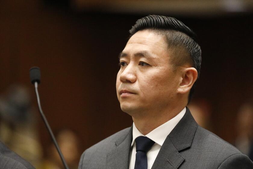 LOS ANGELES, CA - DECEMBER 11, 2018 Los Angeles County Sheriff's deputy Luke Liu, right, appears with his attorney, Michael Schwartz, in a downtown courthouse where he entered a not guilty plea to a charge of voluntary manslaughter in the shooting of Francisco Garcia at a Norwalk gas station on Feb. 24, 2016. (Al Seib / Los Angeles Times)