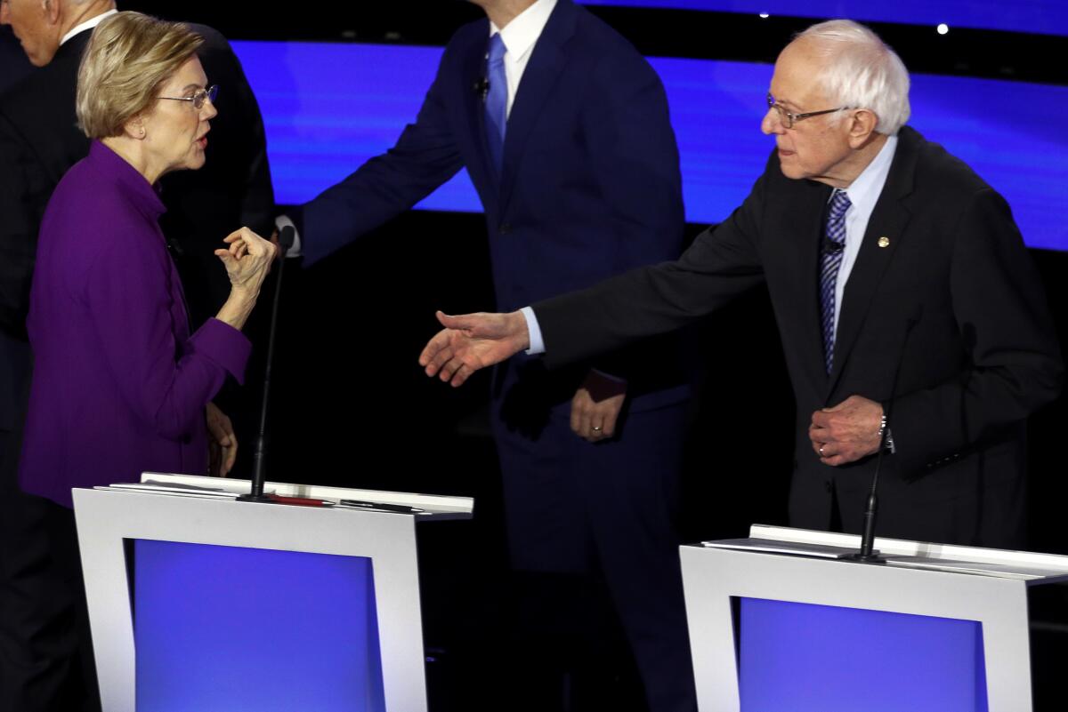 Democratic presidential candidate Sen. Elizabeth Warren and Sen. Bernie Sanders talk Tuesday after a Democratic presidential primary debate hosted by CNN and the Des Moines Register in Des Moines.