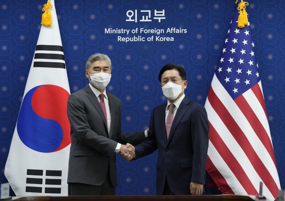 U.S. Special Representative for North Korea, Sung Kim, left, shakes hands with South Korea's Special Representative for the Korean Peninsula Peace and Security Affairs Noh Kyu-duk as they pose for a photo during a meeting at the Foreign Ministry in Seoul, South Korea, Monday, April 18, 2022. (AP Photo/Ahn Young-joon, Pool)