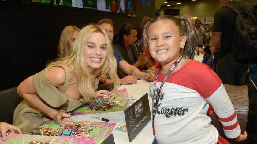 Actress Margot Robbie, left, from the cast of "Suicide Squad" poses with a cosplayer in DC's 2016 Comic-Con booth at San Diego Convention Center Saturday. (Charley Gallay)
