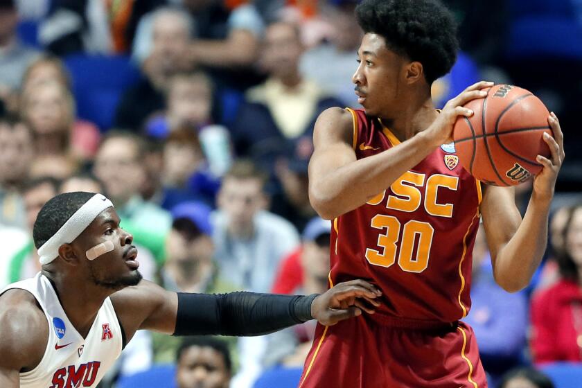 USC guard Elijah Stewart weighs his options as he's defended by SMU guard Ben Emelogu II during the first half Friday night.