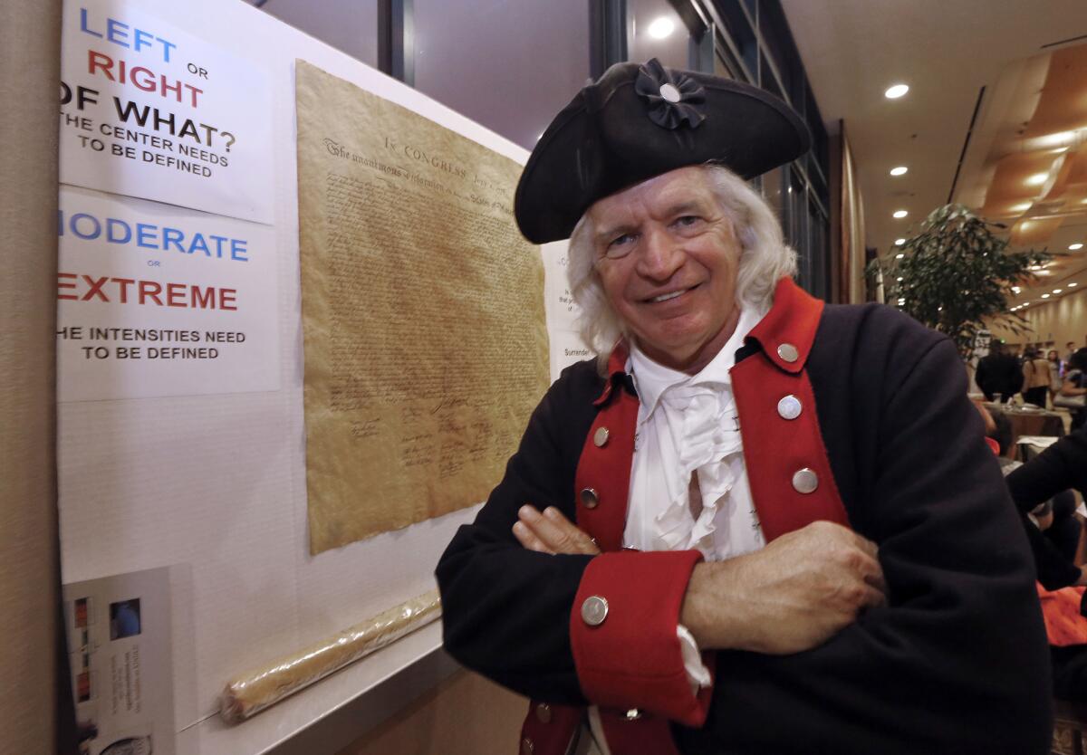 Author Steven Maikoski poses as George Washington next to a replica of the Declaration of Independence at his booth, "Arguing for the Constitution," at the California Republican Party convention in Anaheim.