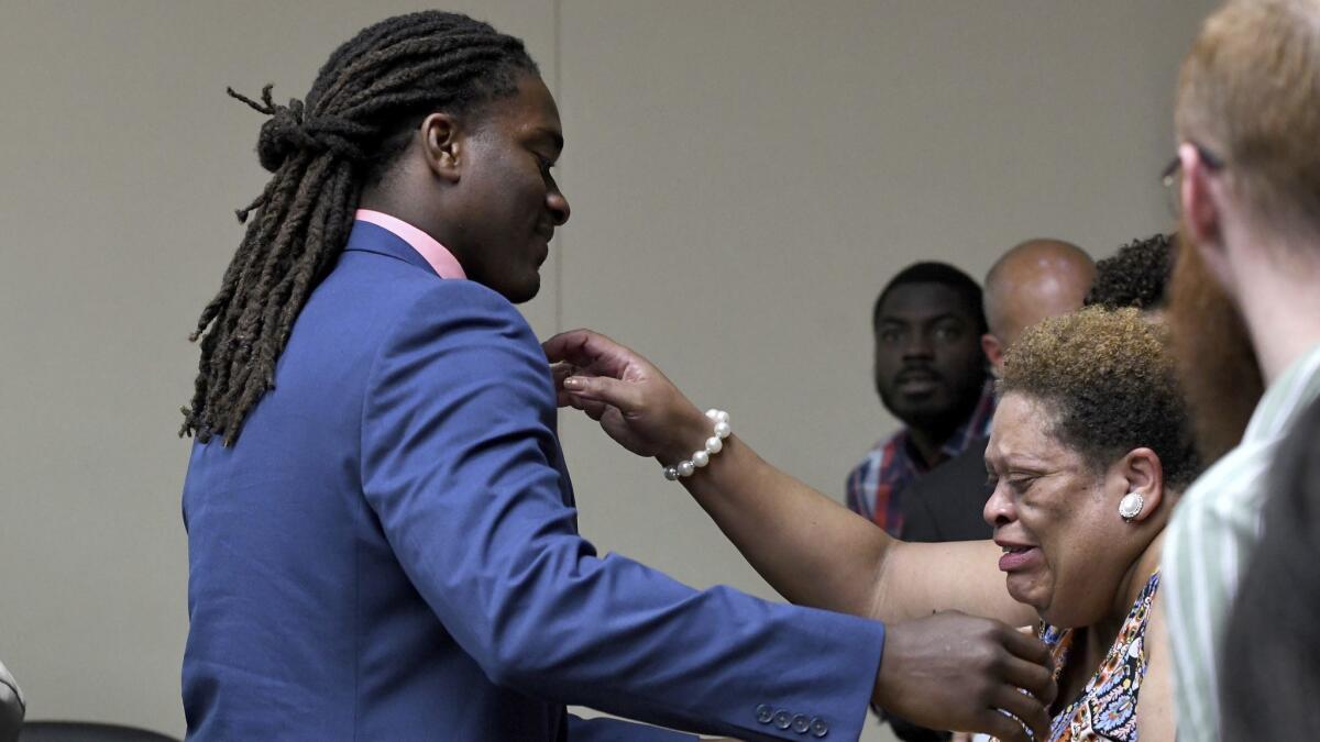 A.J. Johnson reaches to hug a family member after a jury acquitted both Johnson and Michael Williams on aggravated rape charges.