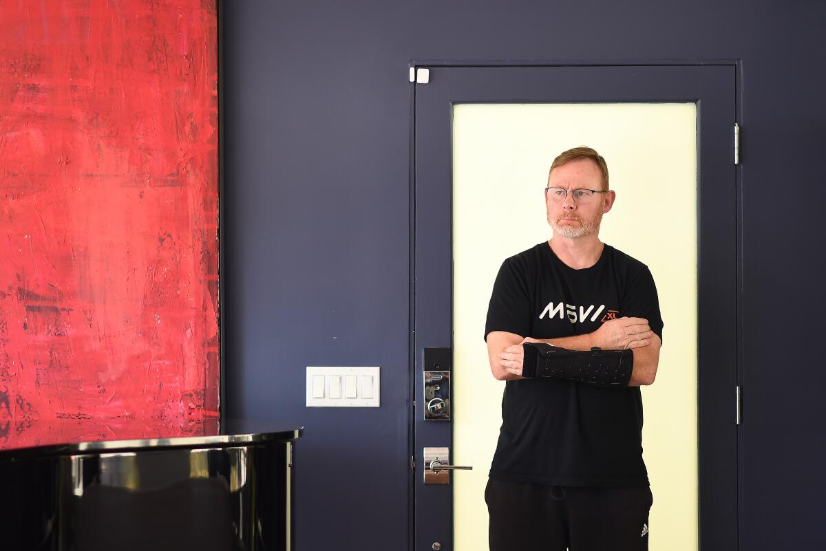 Former Hollywood stunt coordinator Nigel Hudson stands with his arms crossed in a doorway 