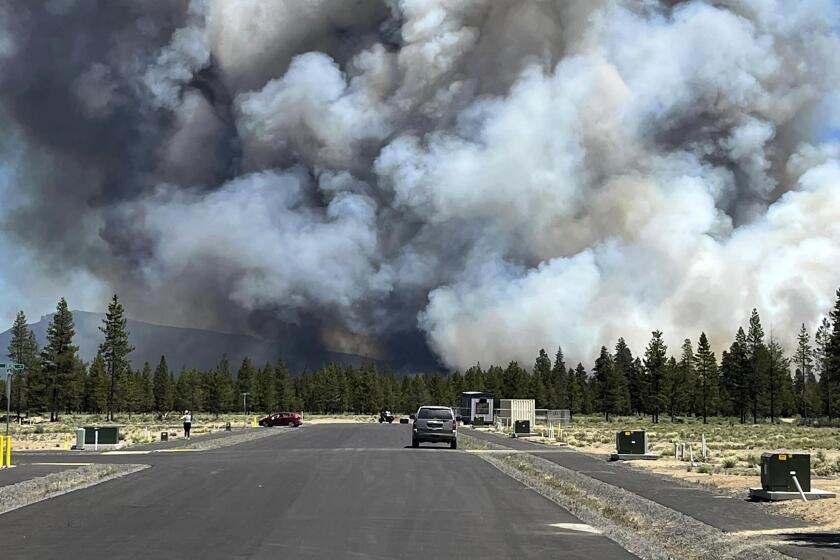 El humo de un incendio forestal se eleva desde una carretera cerca de La Pine, Oregon, el martes 25 de junio de 2024. El fuego provocó evacuaciones obligatorias en la peque?a localidad del centro de Oregon y crecía con rapidez en un entorno seco y caluroso. (Jim Pharris via AP)