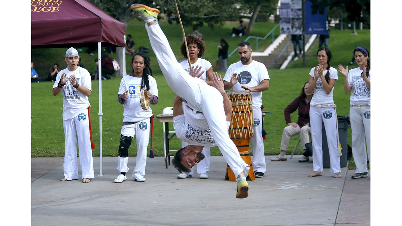 Capoeira Brasil dance team member Julian Chaves does a flip in the air while performing at Glendale Community College during event for International Education Week, on campus in Glendale on Thursday, Nov. 16, 2017.