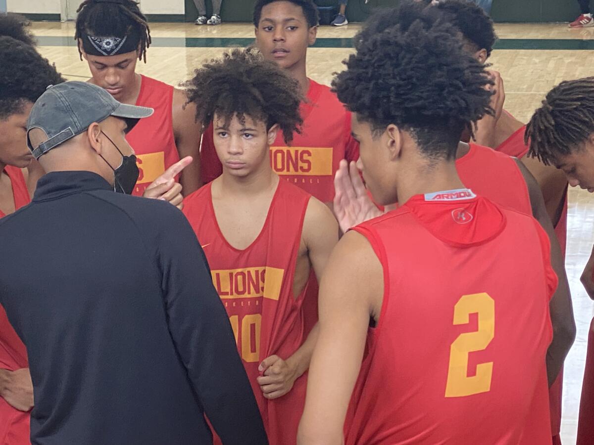 Fairfax coach Reggie Morris Jr. talks to Tyler Bey (No. 2) and guard David Mack.