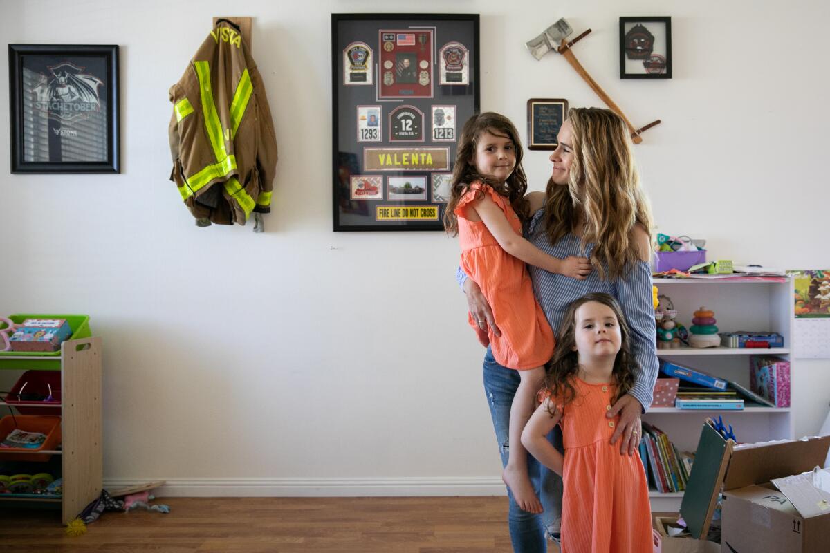 Caylie Valenta poses for a portrait with her daughters Grace, 3, left, and Lily, 5, at their Temecula home.
