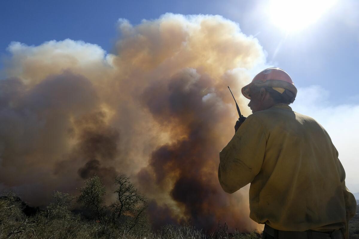 ARCHIVO _  un bombero mira el humo de un incendio forestal en Goleta, California.