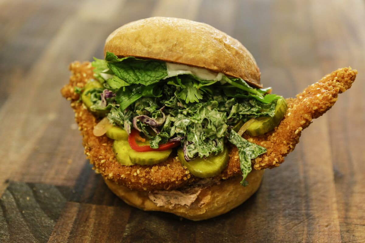 Banh Oui's organic fried chicken sandwich comes with pickles, coleslaw and peppers. 
