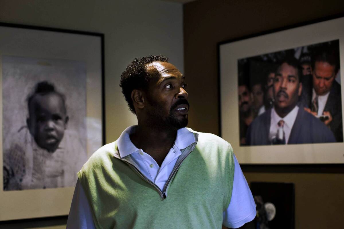 Rodney King poses with a picture of himself that hangs in his home, taken in 1992.