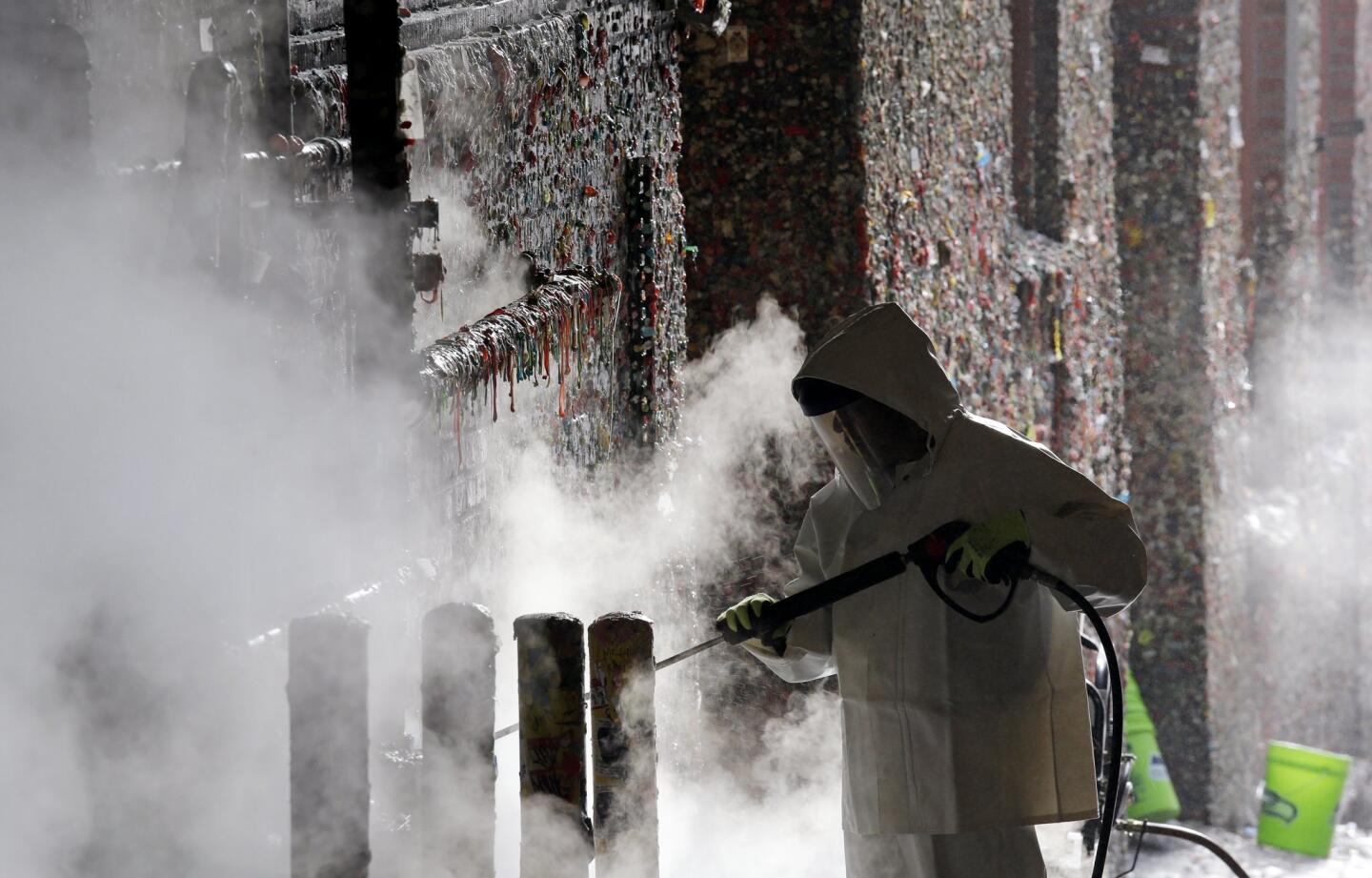 A worker uses a steam cleaner Nov. 10 to work decades of gum off the Market Theater gum wall near Seattle's Pike Place Market. Tourists and locals have been sticking their used gum to the wall for 20 years, leaving an estimated 1 million pieces.