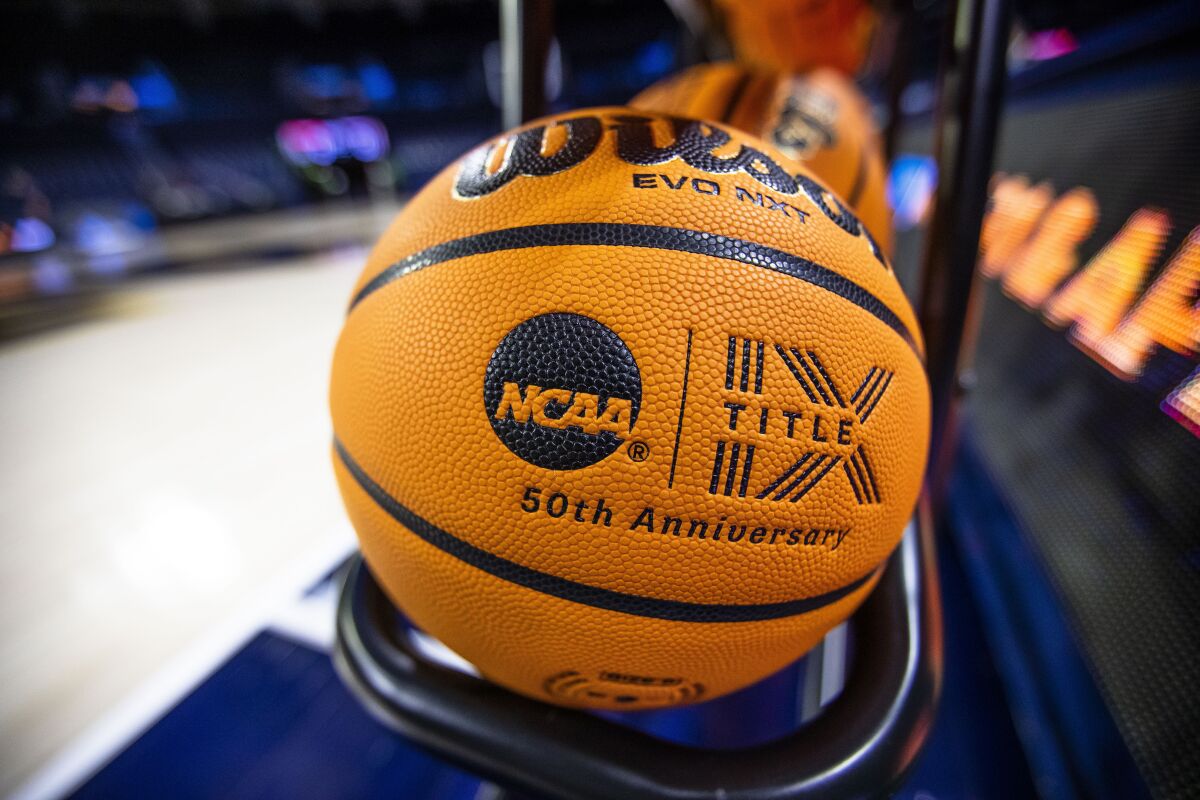 FILE- A basketball with an NCAA logo and a Title IX inscription rests on a rack before a First Four game between Illinois and Mississippi State at the NCAA women's college basketball tournament Wednesday, March 15, 2023, in South Bend, Ind. The NCAA, the organization that governs college athletics, was once at the forefront of hot-button issues such as the Confederate flag and transgender rights. But that stance evolved quickly as one Republican-controlled state after another rushed to pass laws that on everything from abortion to transgender rights. The NCAA’s new approach came into sharper focus this week as Texas prepares to host both the men’s and women’s Final Four. (AP Photo/Michael Caterina, File)