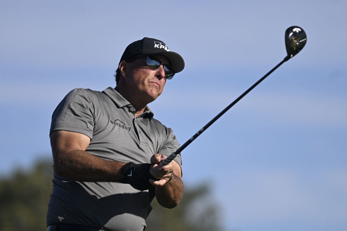 FILE - Phil Mickelson hits his tee shot on the fifth hole of the South Course at Torrey Pines during the first round of the Farmers Insurance Open golf tournament Jan. 26, 2022, in San Diego. Mickelson has said he has asked for a release from the PGA Tour for the option to play in the Saudi-funded LIV Golf Invitational in England. (AP Photo/Denis Poroy, File)