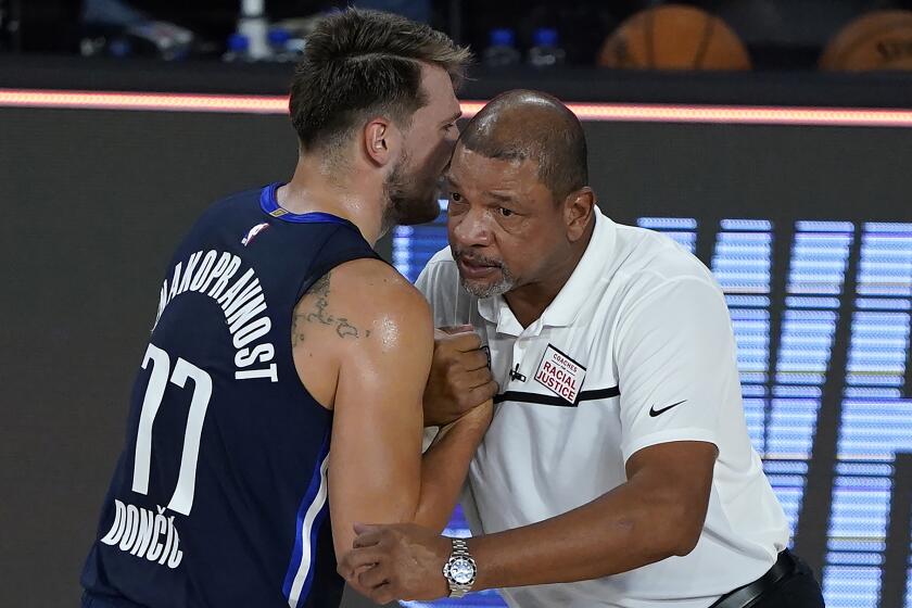 LAKE BUENA VISTA, FLORIDA - AUGUST 06: Luka Doncic #77 of the Dallas Mavericks talks to Head coach Doc Rivers.