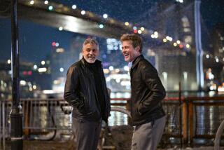 George Clooney and Brad Pitt laugh on a night shoot for their film 'Wolfs' at the South Street Seaport in New York 