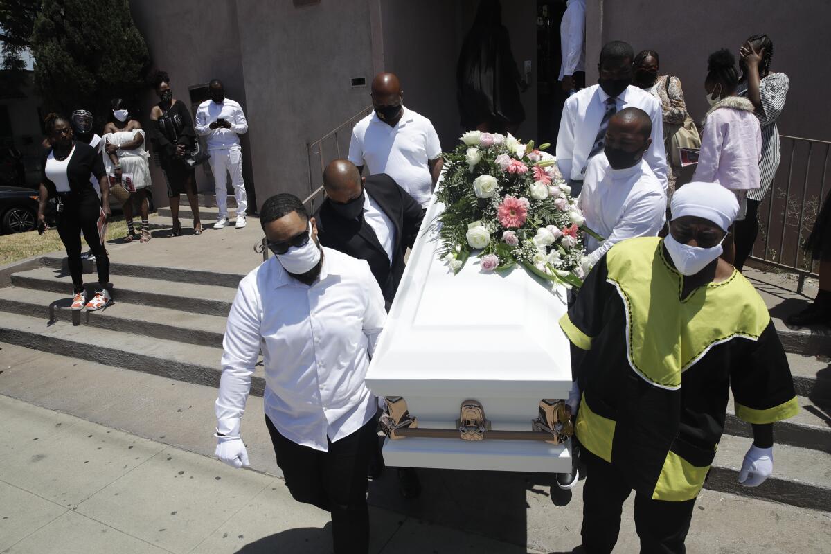 Pallbearers carry a casket.