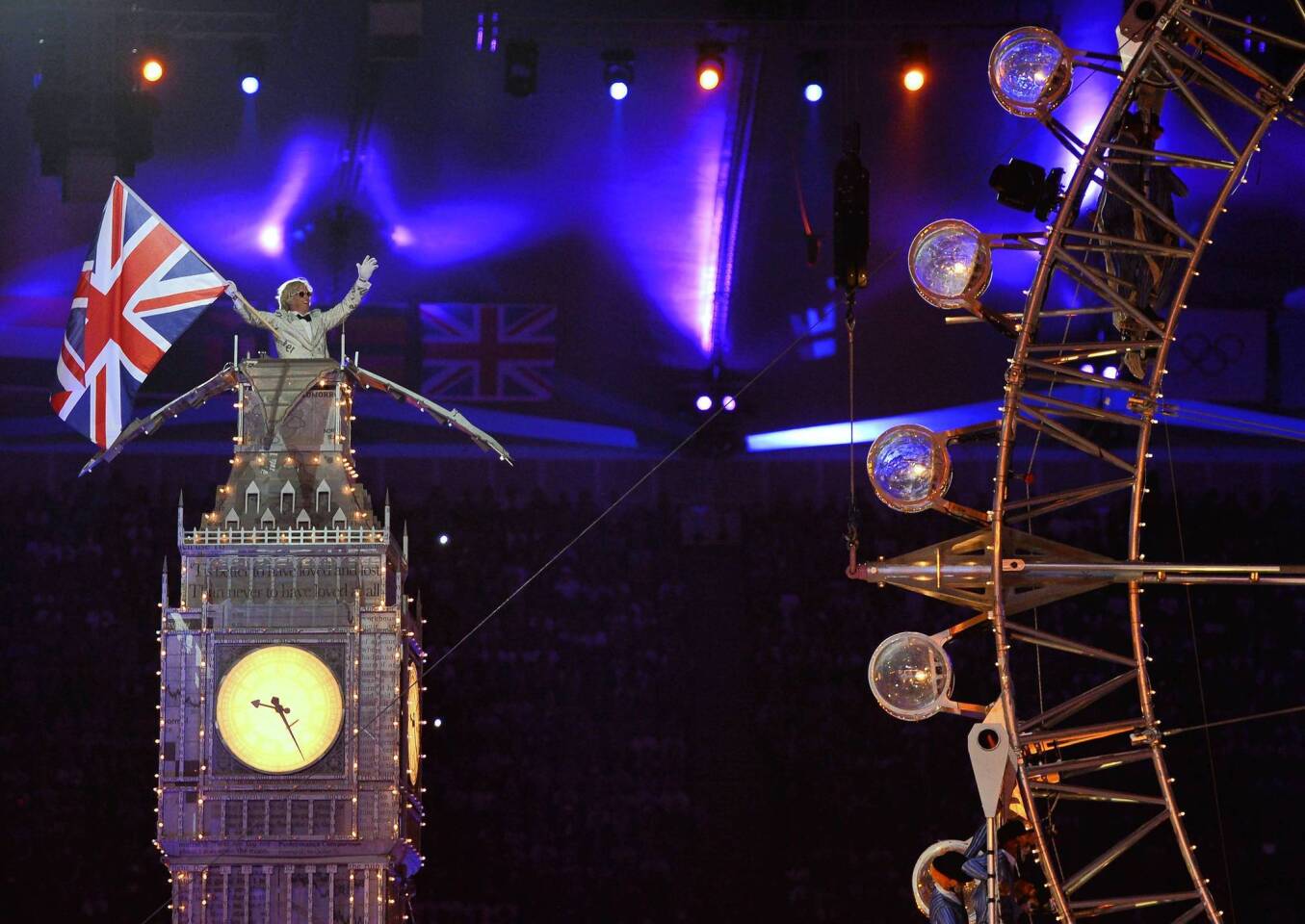 An artist waves a Union Jack flag atop a mock up of the Big Ben tower during the closing ceremony.