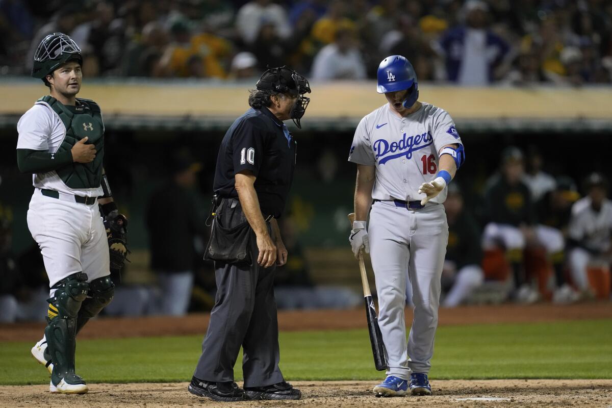 The Dodgers' Will Smith talks to home plate umpire Phil Cuzzi after being called out on strikes during the eighth inning