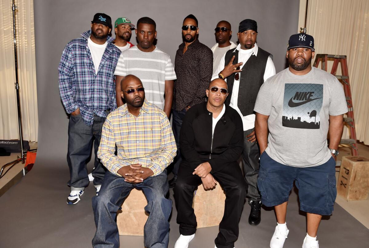 Rappers Masta Killa (seated, left), U-God and, standing from left, Ghostface Killah, Method Man, GZA, RZA, Inspectah Deck, Cappadonna and Raekwon announce they have signed with Warner Bros. Records in Burbank.