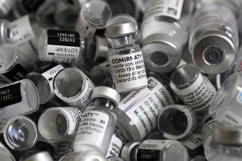 Empty vials of Pfizer vaccine lie in a box