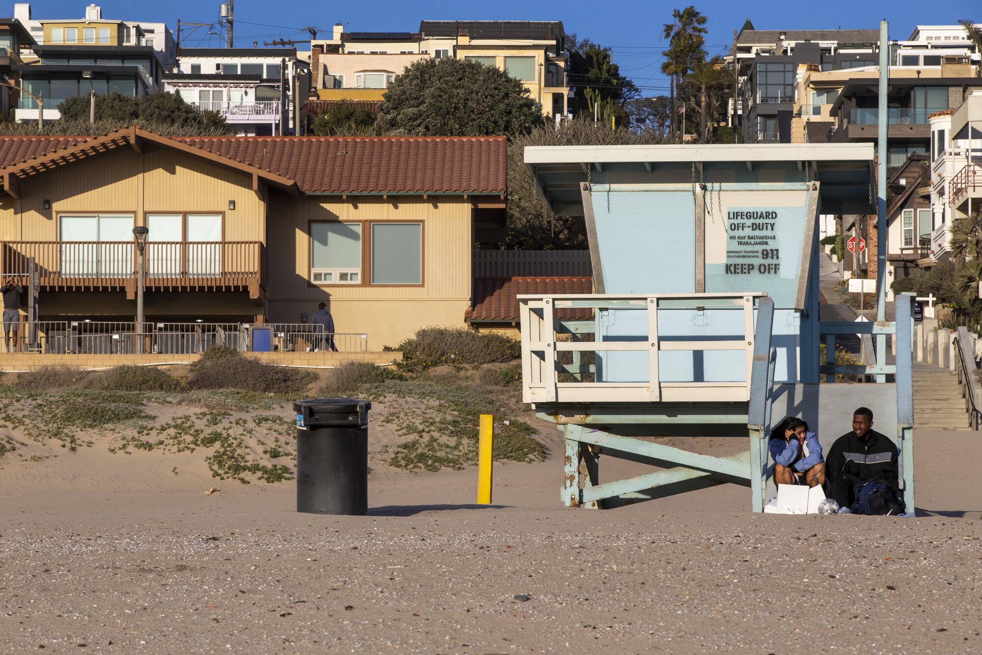 A couple sit on the lifeguard tower between 26th and 27th streets at Bruce's Beach in Manhattan Beach.