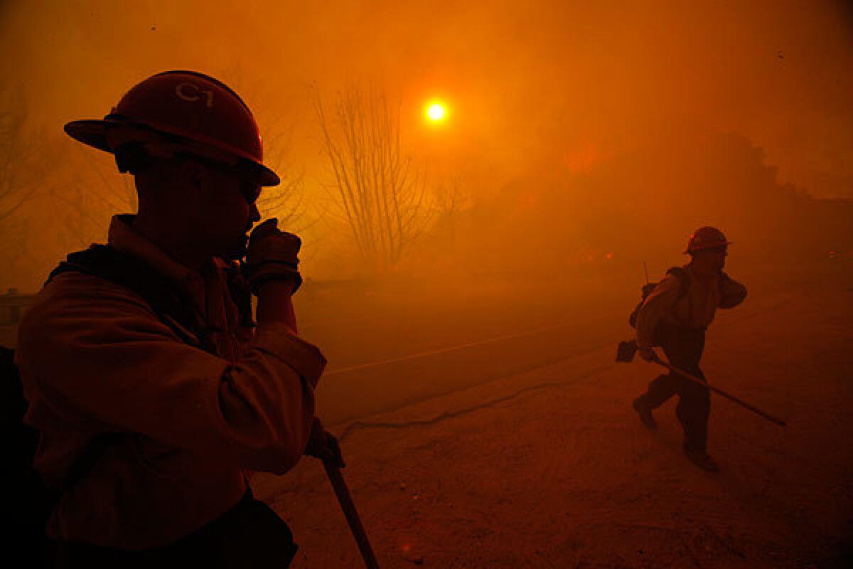At 8:07 a.m., thick smoke blankets the sky as fire crews try try to contain the flames.