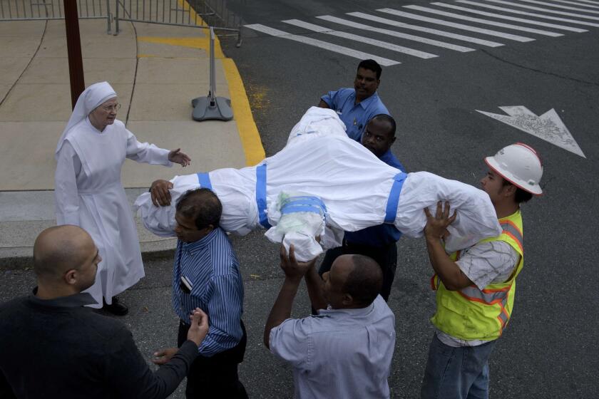 Workers from the Little Sisters of the Poor Nursing Home deliver a crucifix to the Basilica of the National Shrine of the Immaculate Conception in preparation for Pope Francis' visit this week in Washington.