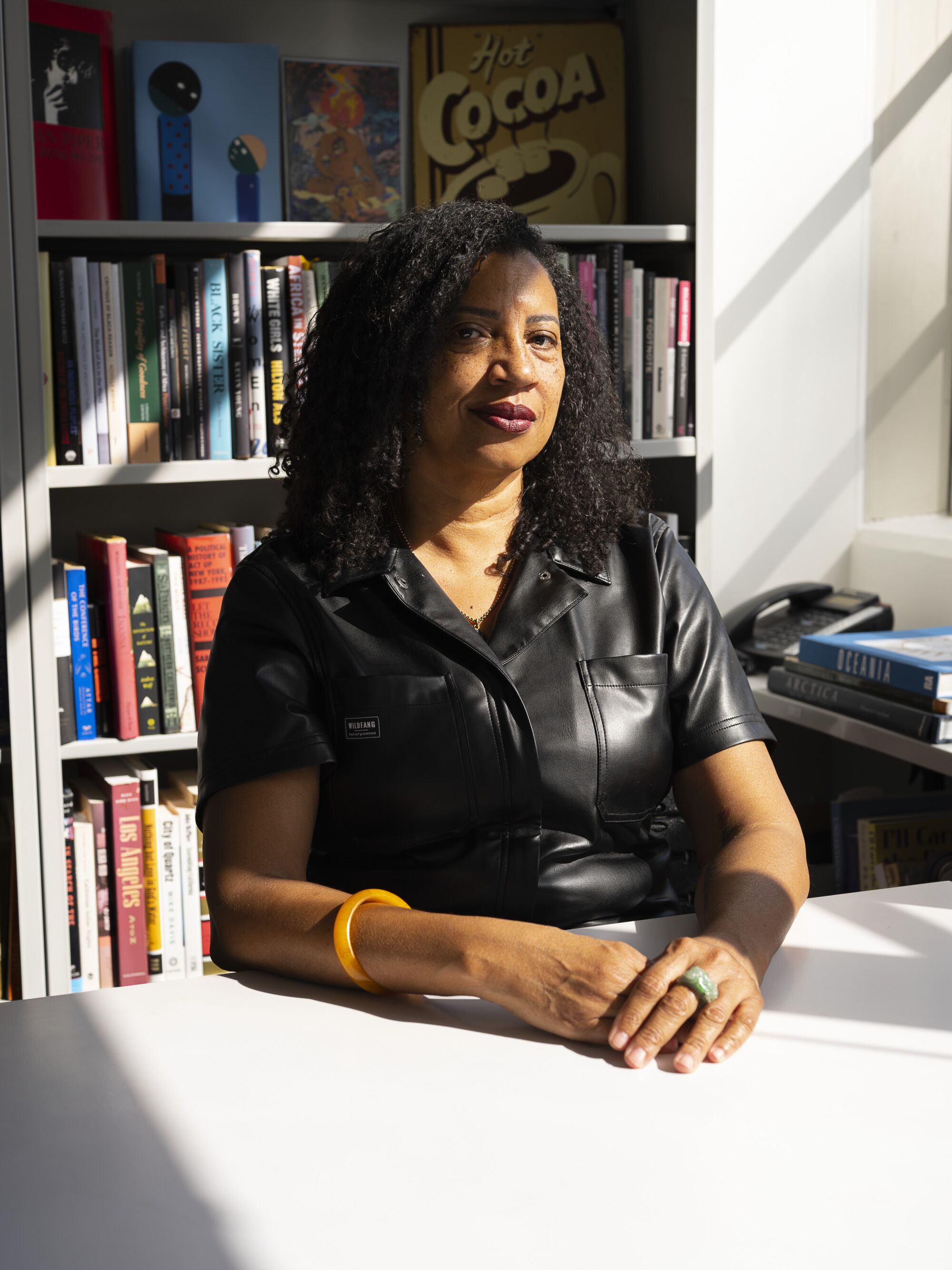 Robin Coste Lewis seated at her office at USC, a bookcase behind her.